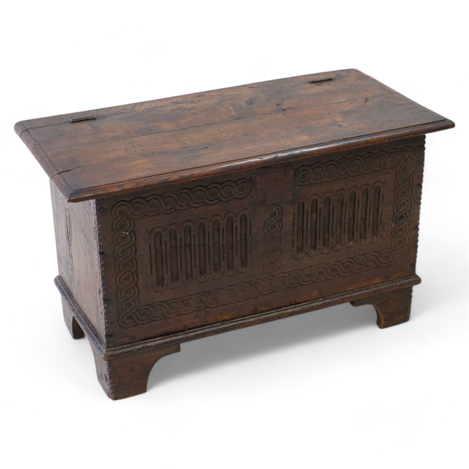 18th century and later plank kist, rectangular form, moulded hinged lid over guilloche and fluted front with chip carved edge, on bracket feet 