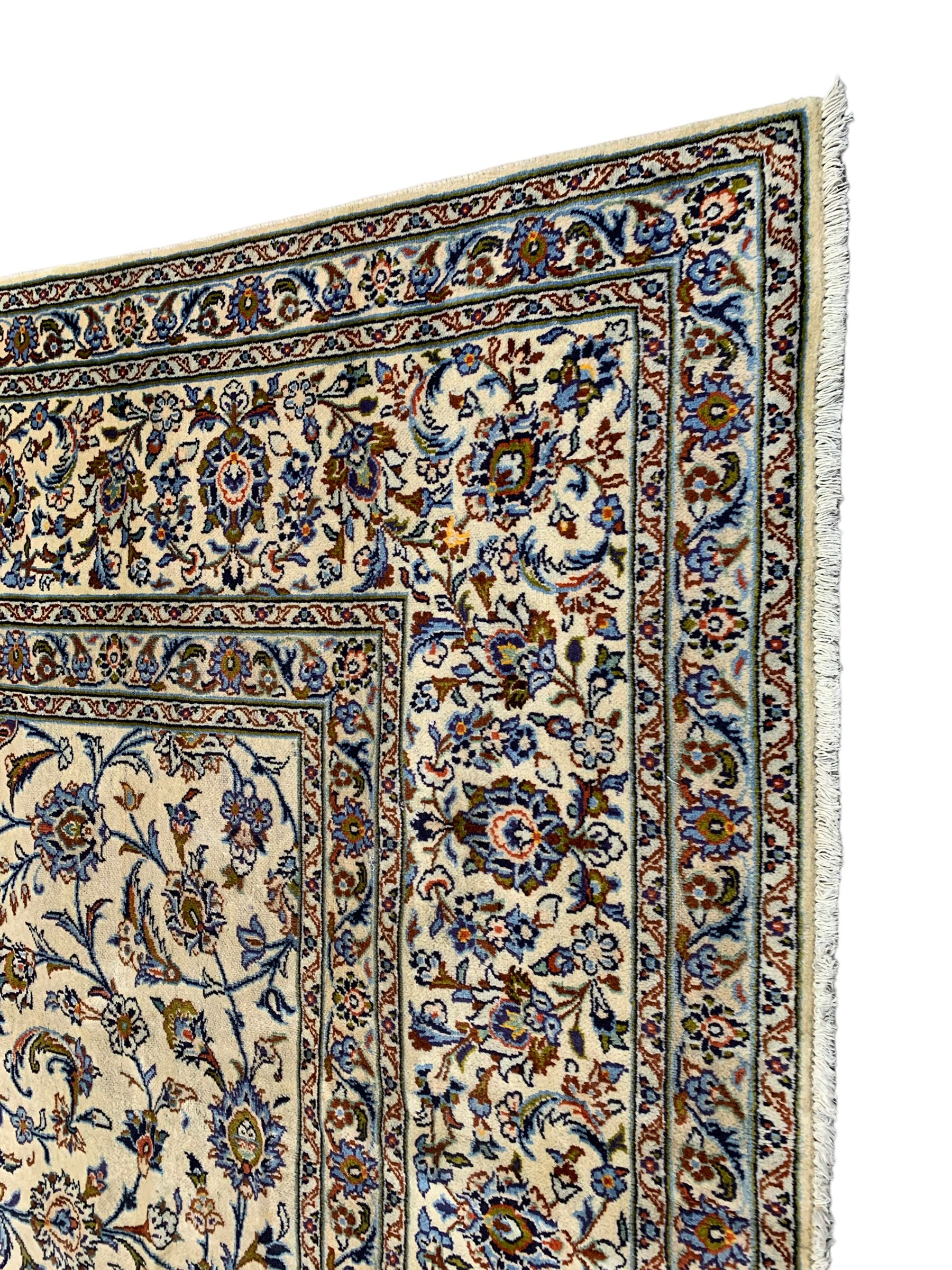 Persian Kashan ivory ground carpet, the field decorated with interlacing leafy branches and stylised plant motifs, repeating border with multiple guards