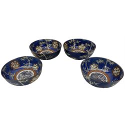 Set of four Japanese graduating porcelain bowls, each centrally painted with a coiled dragon in reserves, bamboo and foliate roundels against a blue ground, largest measuring D24.5cm (4)