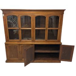 Mid-to-late 20th century Burmese teak wall cabinet, four glazed doors over four panelled doors, on moulded plinth base 