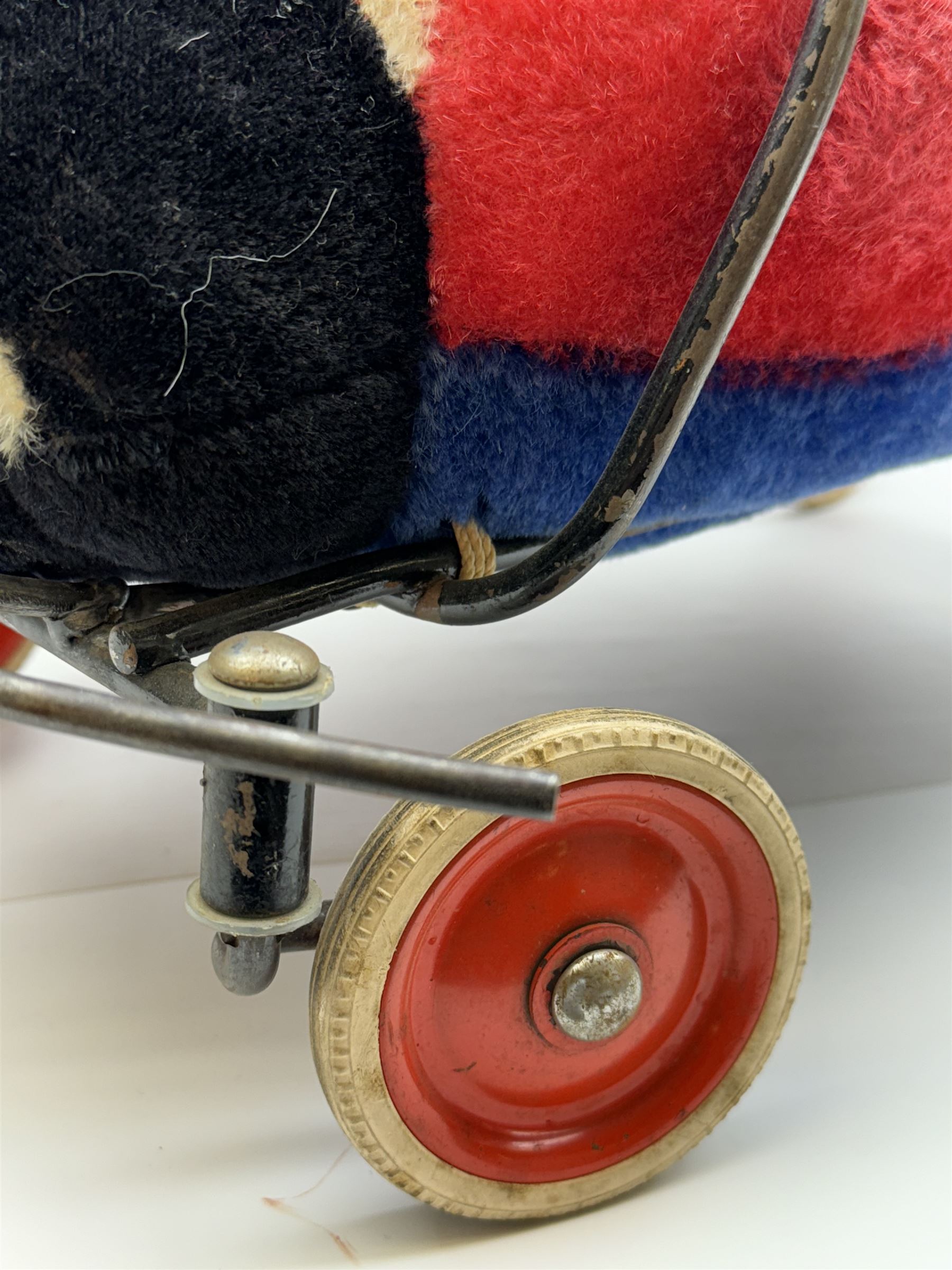 Steiff child's ride on ladybird, circa 1950s, the mohair body with red and black spotted seat, black and white face and blue underbelly, upon a metal frame with rubber and metal wheels, H30cm, W52cm