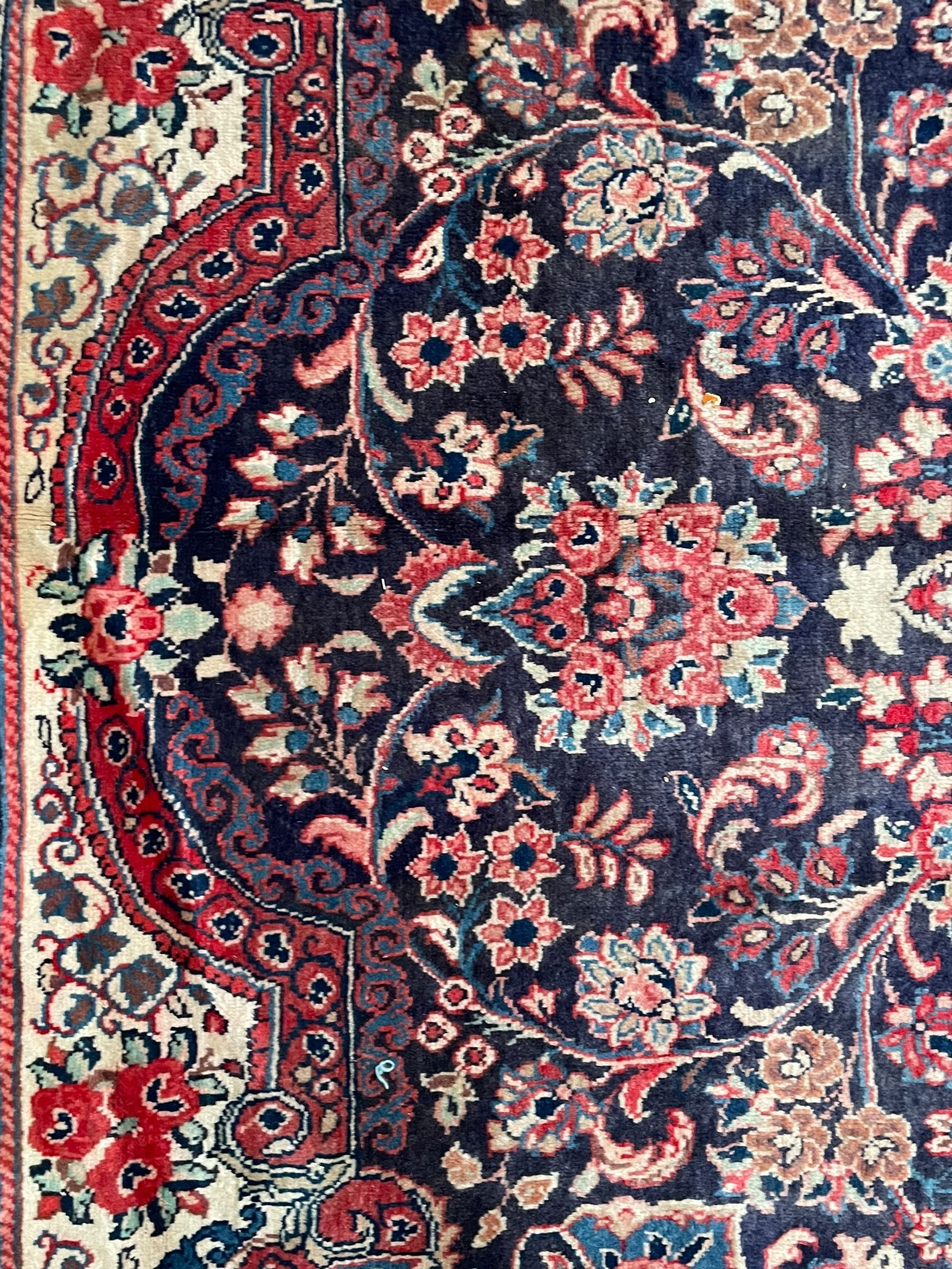 Persian Mahal indigo ground carpet, floral medallion on a field of swirling leafy branches and flower heads, shaped ivory field band decorated with flower head bouquets and trailing branches, the border decorated with floral motifs, within guard stripes