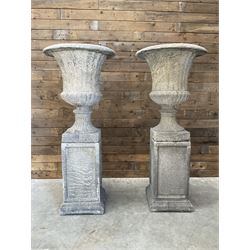 Pair of large Georgian design cast stone garden urns, egg and dart border, tapering column on square base, raised on square column