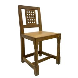 Mouseman - set of six oak dining chairs, pierced and carved lattice panel back over tan leather seat with studded band, on octagonal front supports united by plain H stretchers, carved with mouse signature, by the workshop of Robert Thompson, Kilburn 