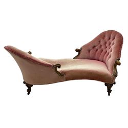 Victorian walnut framed tete-a-tete loveseat, scrolled arm terminals with moulded foliate decoration, buttoned backs and sprung seat upholstered in pale pink velvet, raised on cabriole supports with applied flower heads and scroll feet terminating to ceramic castors