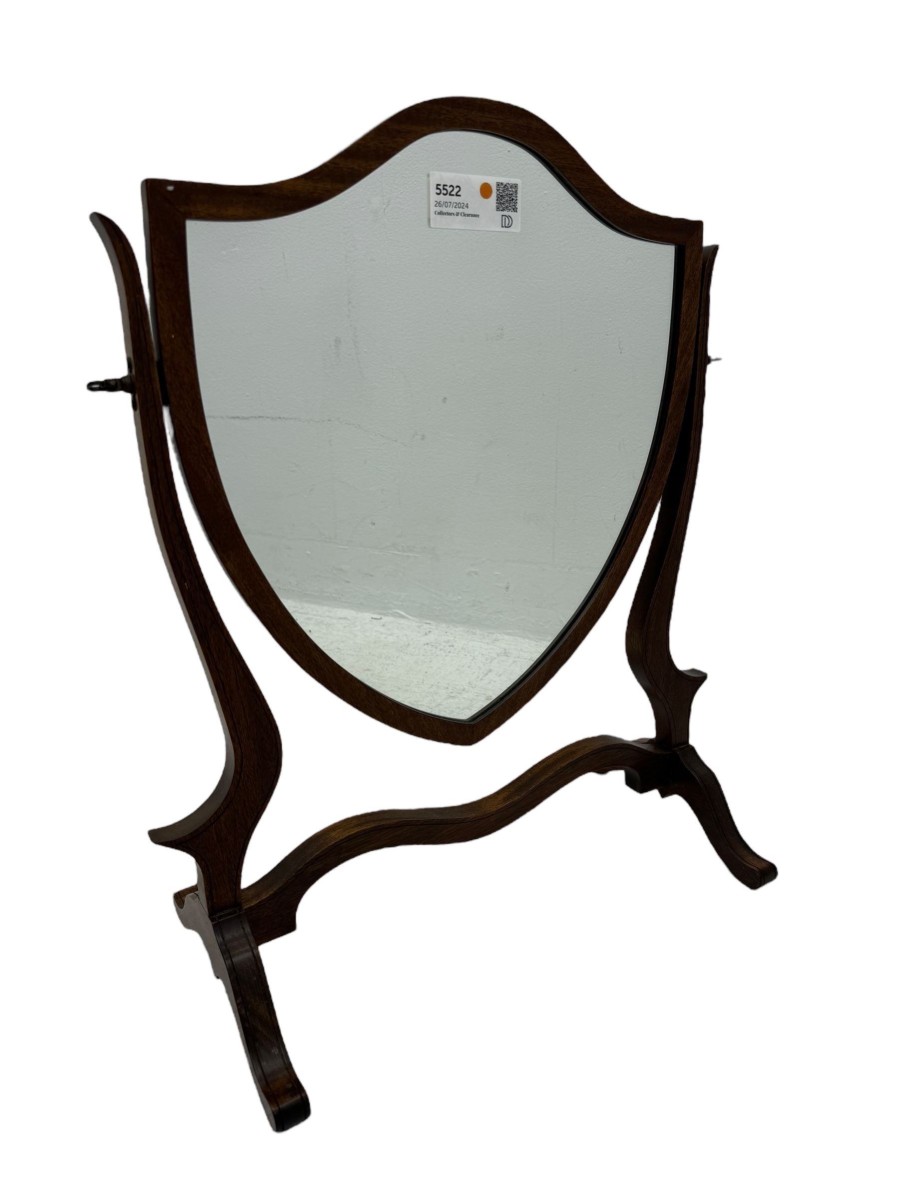 Edwardian mahogany shield-shaped dressing mirror, shaped frame with swivel function, on scroll supports connected by curved stretcher 