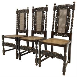 Set of seven (5+2) 19th century Carolean design oak dining chairs, scroll leaf and flower head carved cresting rail over spiral turned uprights and cane work back, the cane work seat on spiral turned supports united by plain stretchers, scrolled leaf carved middle rail 