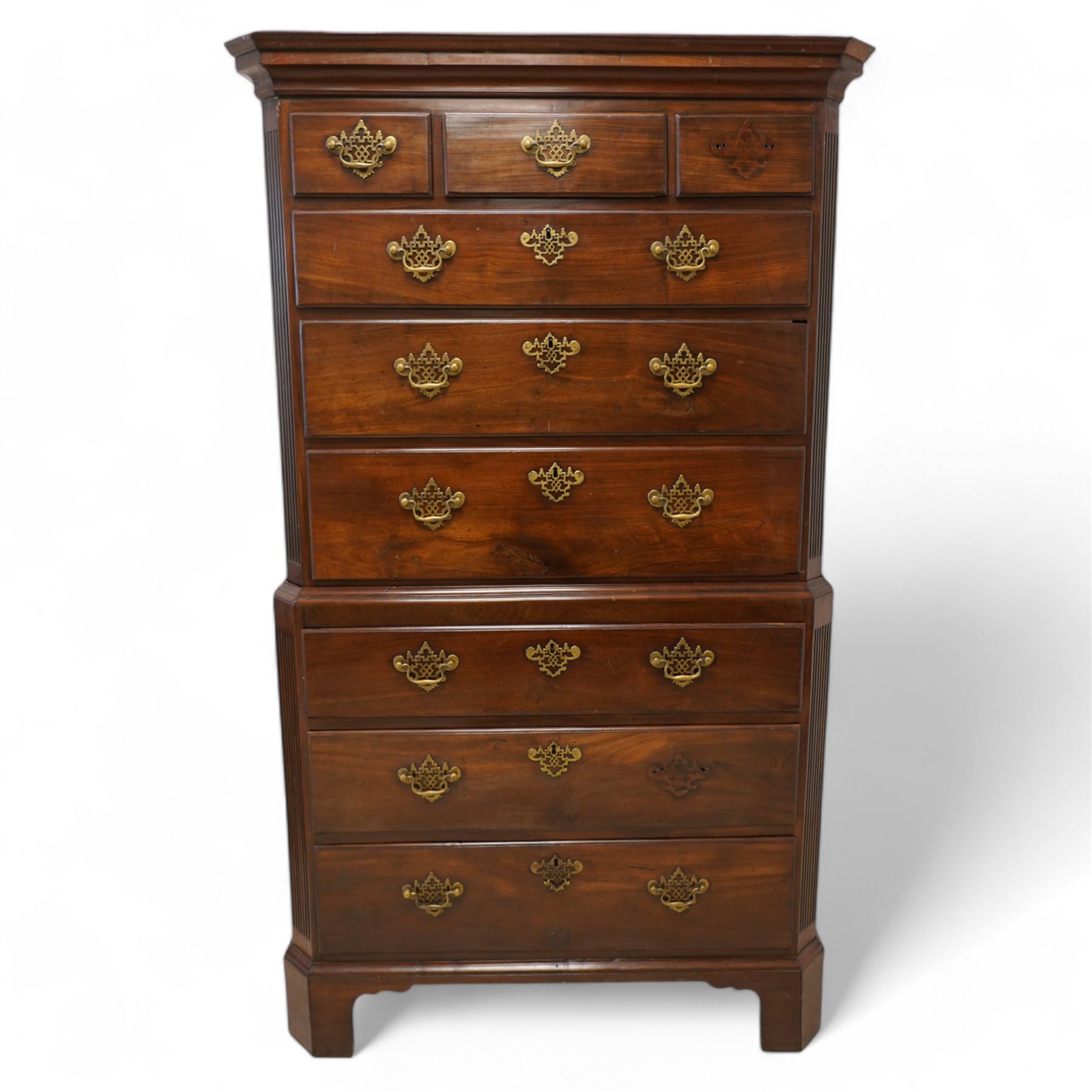 George III mahogany canted chest-on-chest, moulded cornice over three short and six long moulded drawers, shaped and pierced handle plates with swan neck handles, fluted upright canted corners, on bracket feet 