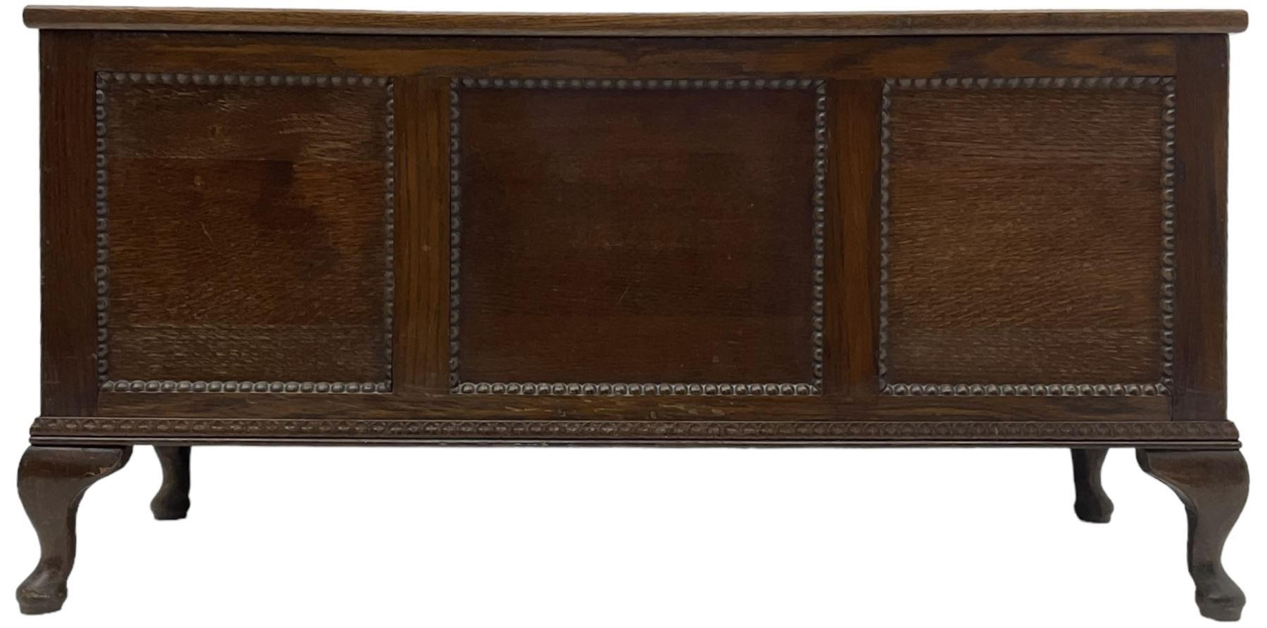 Early 20th century oak blanket chest, rectangular hinged lid with decorative panelling, the front and sides adorned with beaded panels, on cabriole feet