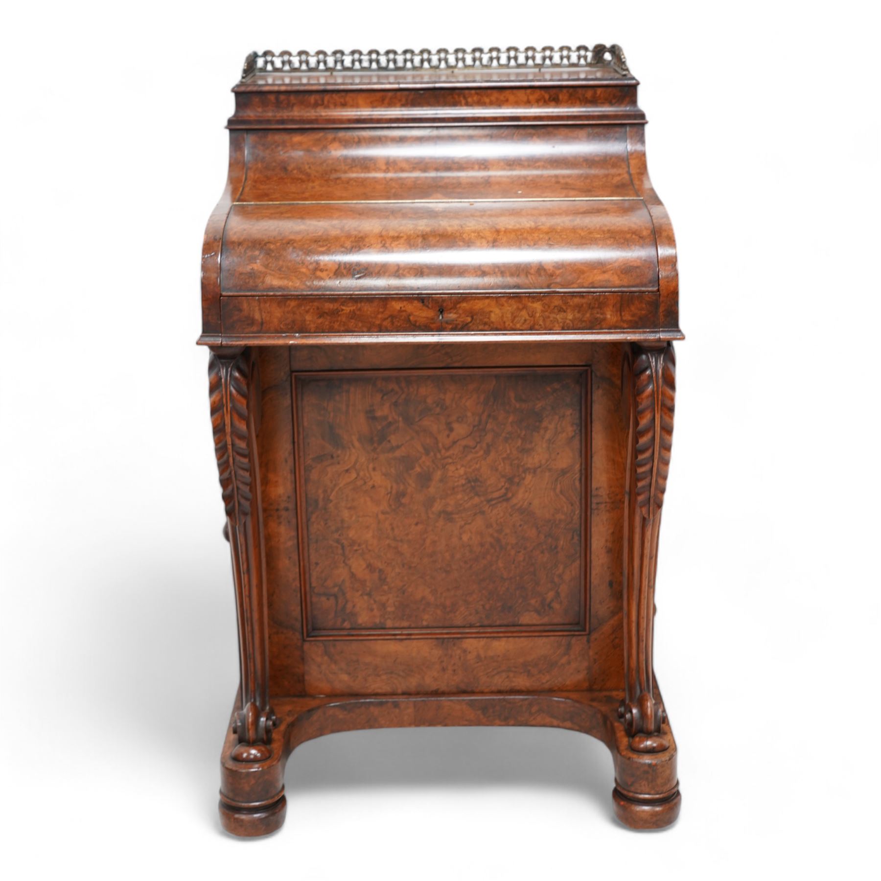 Victorian figured walnut piano top Davenport, the moulded top with brass gallery opens to reveal hidden compartment fitted with divisions, the piano lid enclosing slide with hinged leather writing surface, pen holder and two drawers, the right-hand side fitted with four drawers and the opposing side with four false drawers, on acanthus carved cabriole supports with scrolled terminals, sledge platform on turned feet 