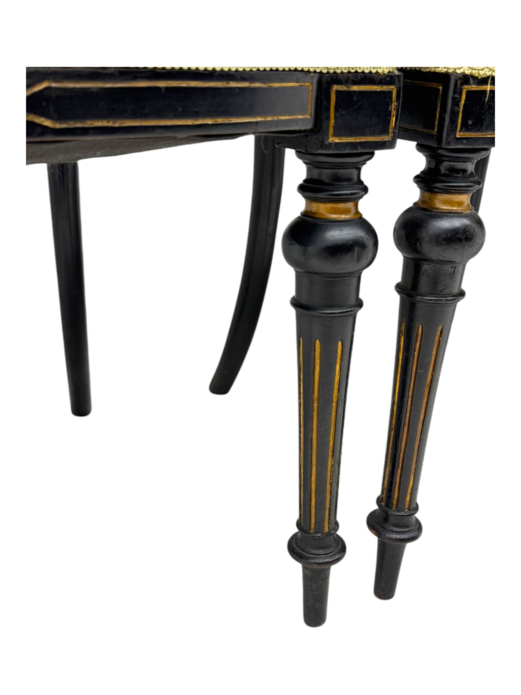 Set of four late Victorian ebonised dining chairs, decorated with carved and gilt foliate decoration, upholstered seats, on turned and fluted front supports 