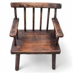 Vernacular 'Irish famine' or 'primitive' pine chair, bar cresting rail over spindle back, flat arms on thick plank seat, rounded supports 