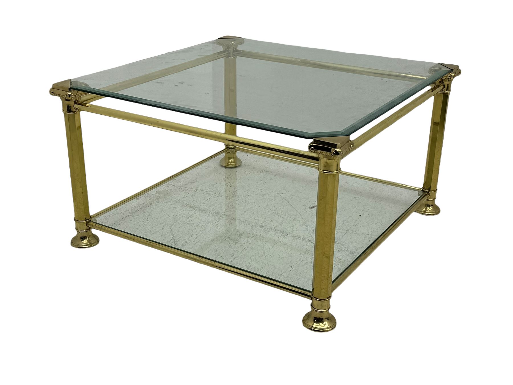 Mid 20th century brass and glass coffee table, square glass top with bevelled edges over undertier, supported by brass columns joined by crossbars, on circular feet