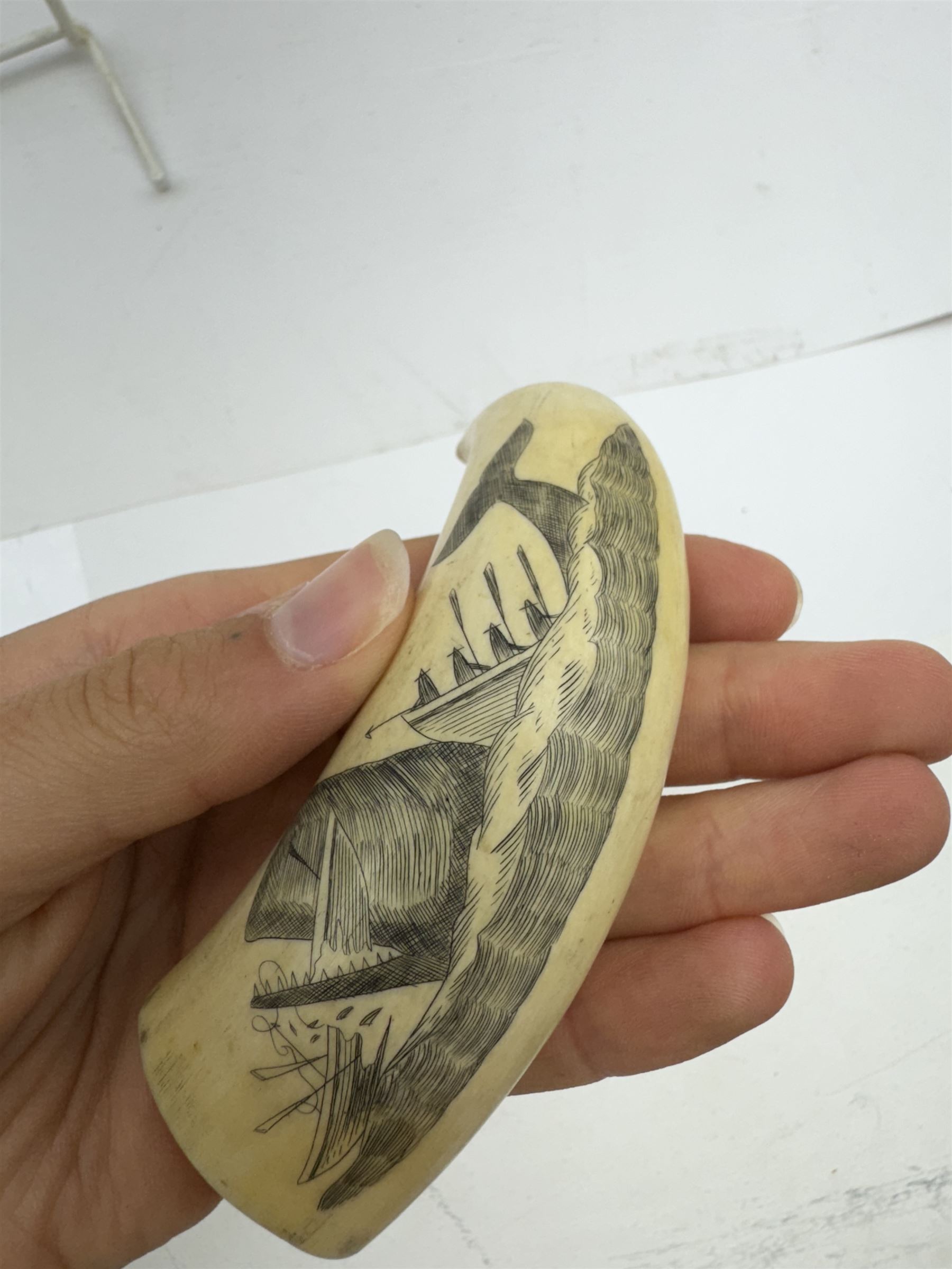 19th century scrimshaw whale tooth, depicting a whale destroying a boat, L9cm