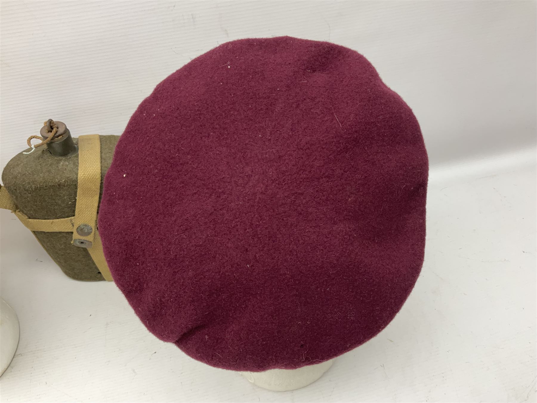 Five military caps/berets comprising two peaked caps with 'Yorkshire' and 'Royal Engineers' badges; maroon beret with parachute regiment badge; red beret with Military Police badge; and AB seaman hat with HM Submarines band; and a felt and webbing covered water bottle (6)