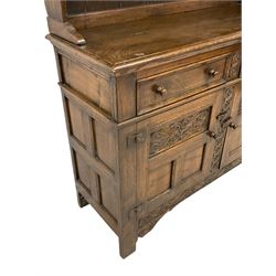 Georgian design oak dresser, two-tier plate rack with shaped aprons, the base fitted with two fielded moulded drawers, over two panelled cupboards carved with scrolling acanthus leaves, with guilloche carved central upright, on stile feet