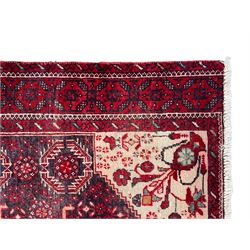 Persian Baluchi dark indigo and crimson ground rug, the field decorated with rows of repeating Pitrak motifs and surrounded by small bird and flower head motifs, floral urn decorated spandrels, repeating Pitrak border within guard stripes