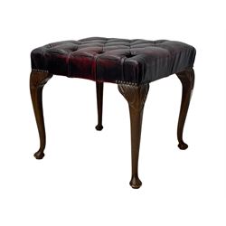 Chesterfield three-seat sofa, traditional shaped upholstered in deeply buttoned dark red leather; together with similar footstool 