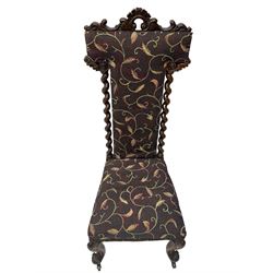 Victorian walnut prie-dieu chair, cresting rail carved with cartouche and extending scrolling foliage, back flanked by spiral turned column uprights, upholstered in foliate patterned fabric, raised on cabriole supports with scroll feet and castors