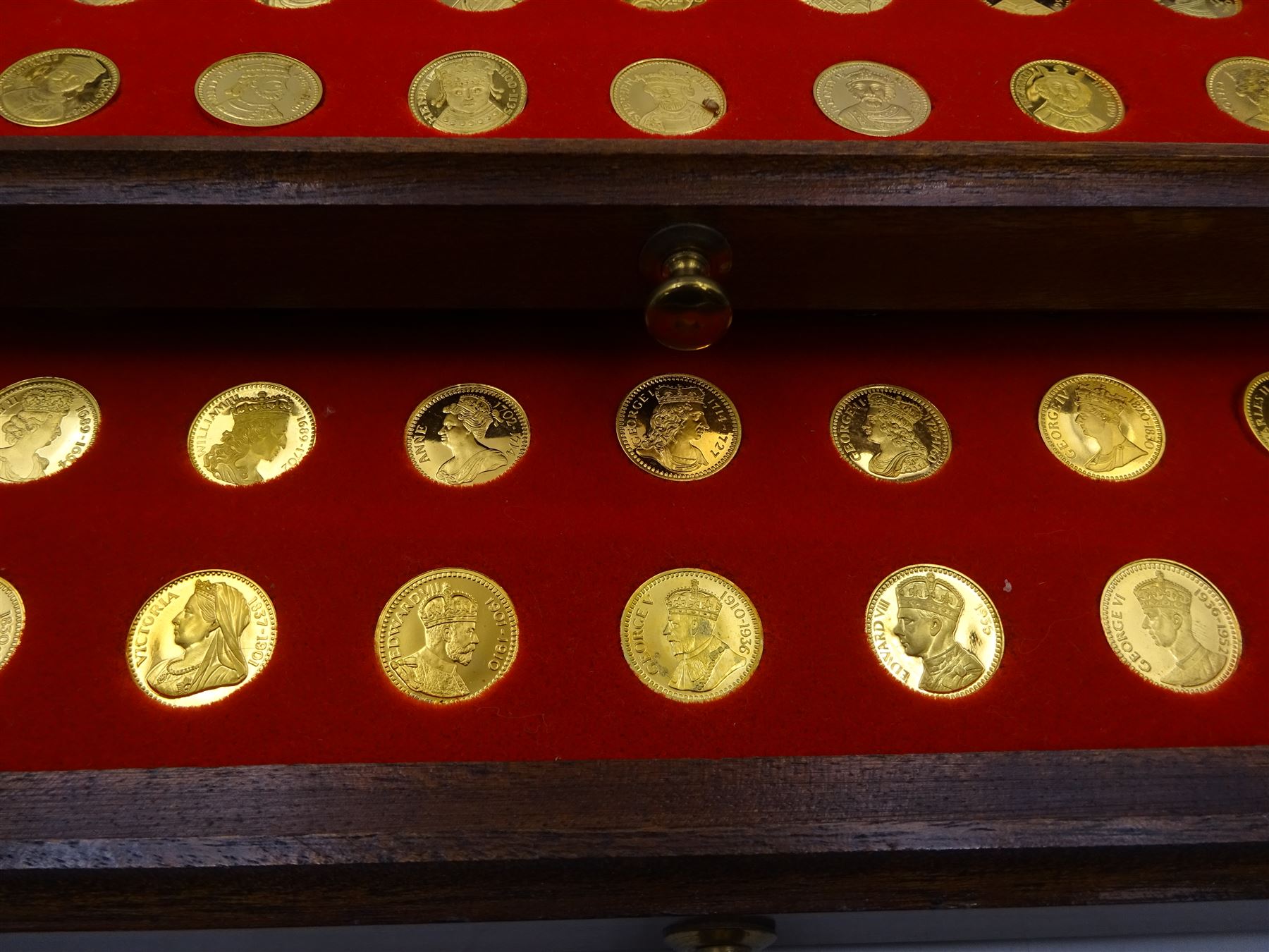 Danbury Mint, Our Royal Sovereigns Collection, seventy 22 carat gold plated silver medallions depicting the complete line of British monarchs to mark the 1200th anniversary of the first coronation, contained within wooden table top collectors cabinet with two drawers, with certificate of authenticity, with two drawers, hallmarked Danbury Mint, London various dates