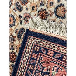 Indo-Persian Herati design ivory ground rug, central medallion on a field of repeating floral Herati motifs, peach ground border with repeating pattern, enclosed by guard stripes 