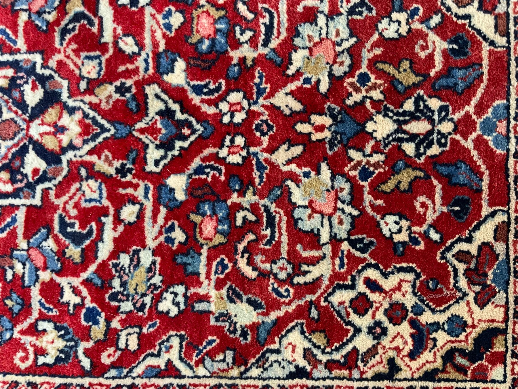 Persian crimson ground rug or mat, field decorated with central medallion and all-over scrolling floral motifs, border with repeating palmettes