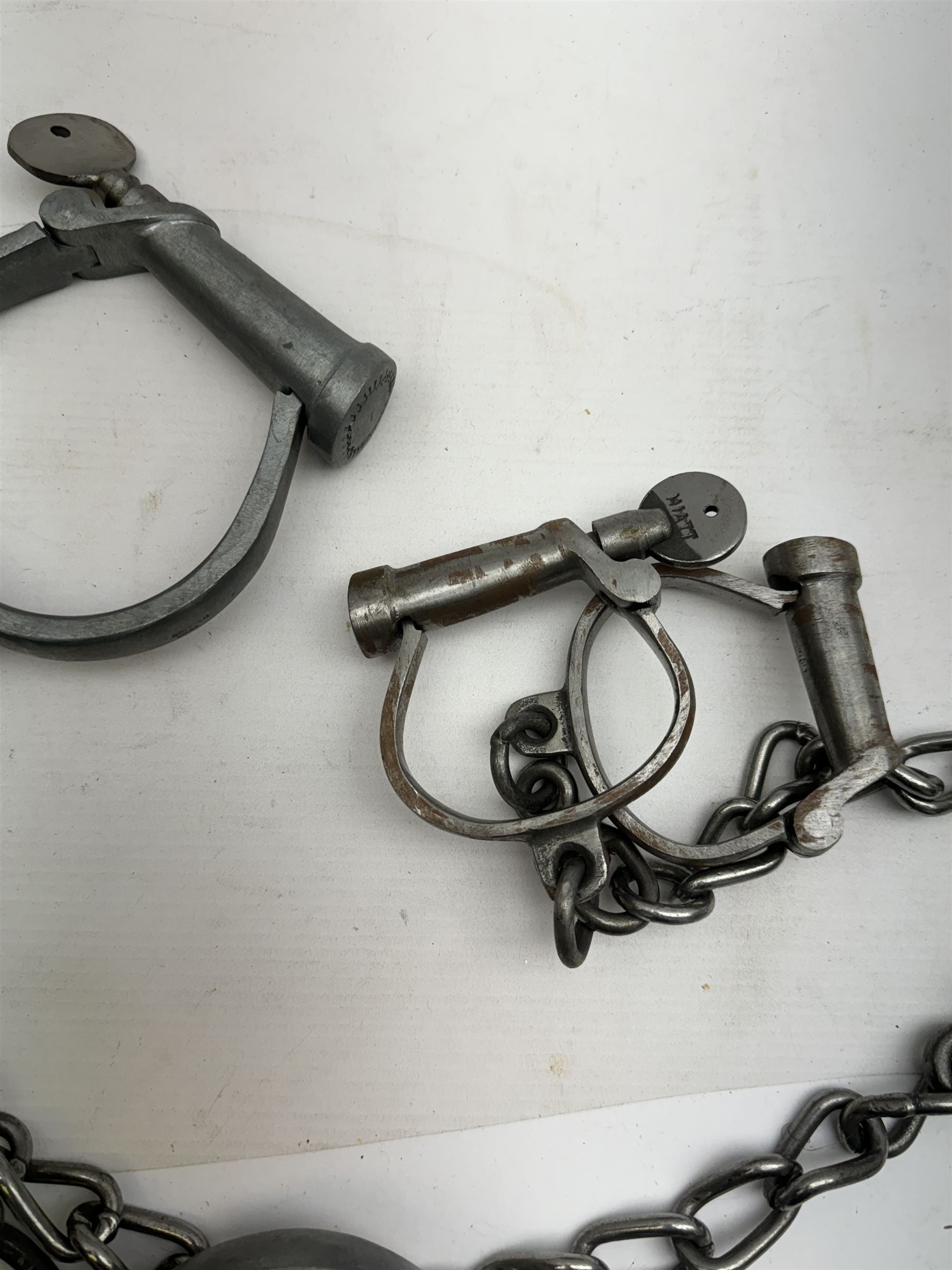 Hiatt handcuff and leg chains, together with leather collar with brass cow bells and similar items 