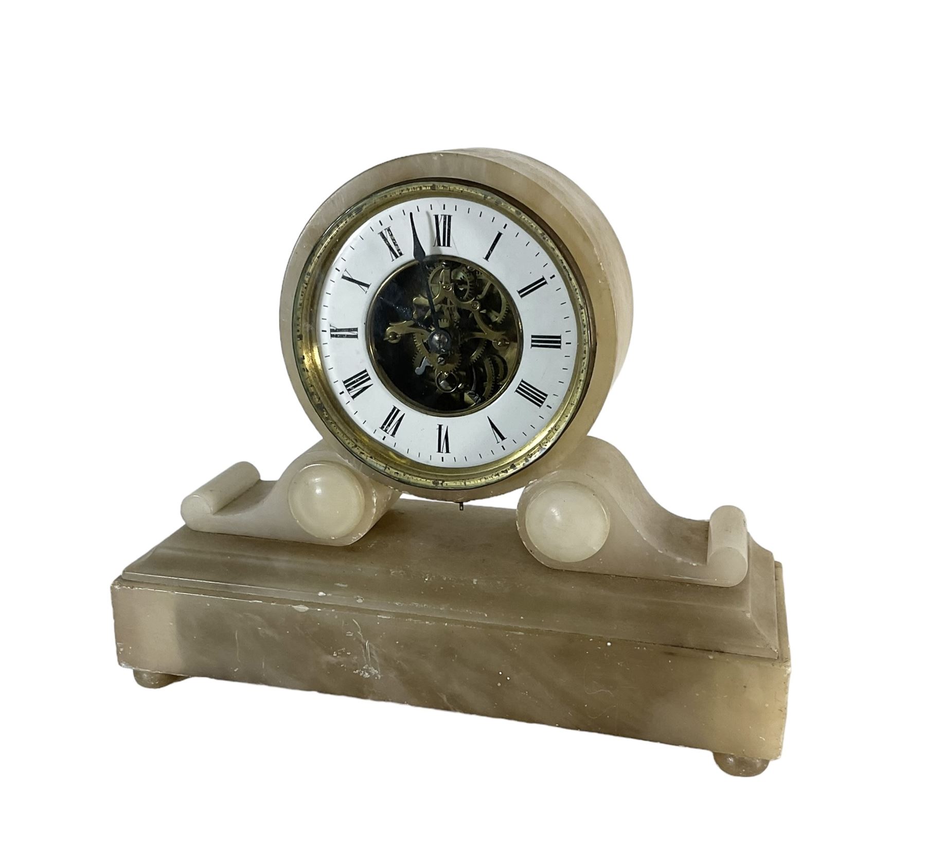 French - late 19th century 8-day mantle clock in an alabaster case,  with a drum movement raised on scroll supports and stepped plinth, open dial displaying the skeleton movement, escapement and motion work, enamel chapter with Roman numerals and spade hands enclosed within a glazed brass bezel, single train tick tac escapement with integral pendulum, wound and set from the front.