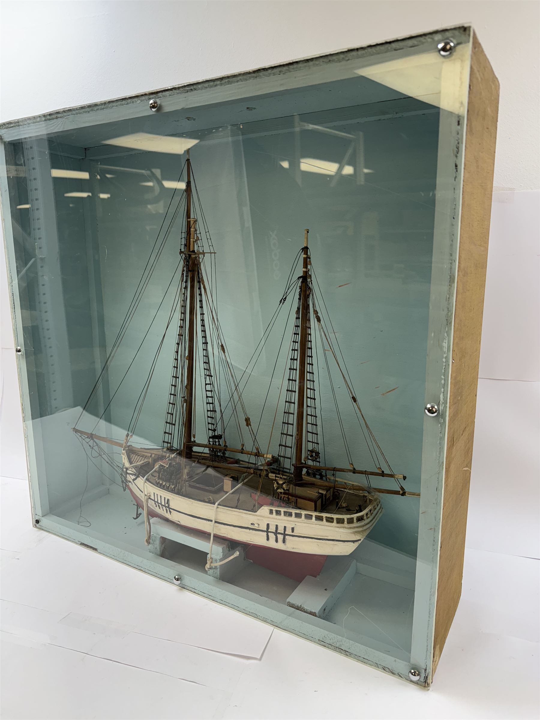 Scratch built model of a two-masted schooner, the red and white painted wooden body numbered GC-3-893, contained within wooden case, the interior painted in a light blue, with carry handle, excluding handle case H64.5cm, W67cm