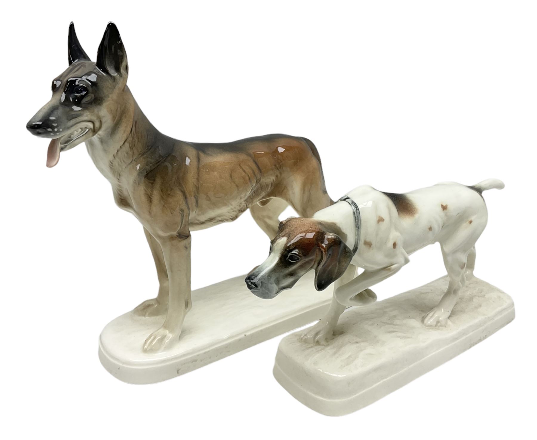 Two Hertwig and Co Katzhutte figures of dogs, comprising a German Shepherd and a pointer dog, both with printed marks beneath, largest H21.5cm W25cm