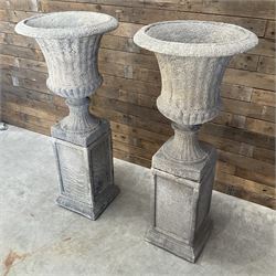 Pair of large Georgian design cast stone garden urns, egg and dart border, tapering column on square base, raised on square column