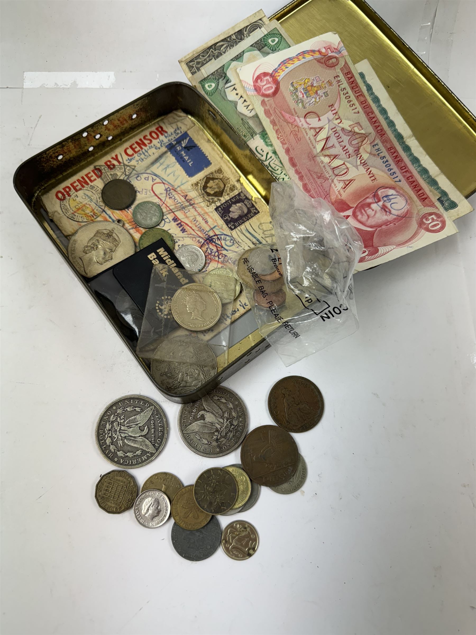 Various coins and banknotes including two Morgan dollars, in a vintage tin