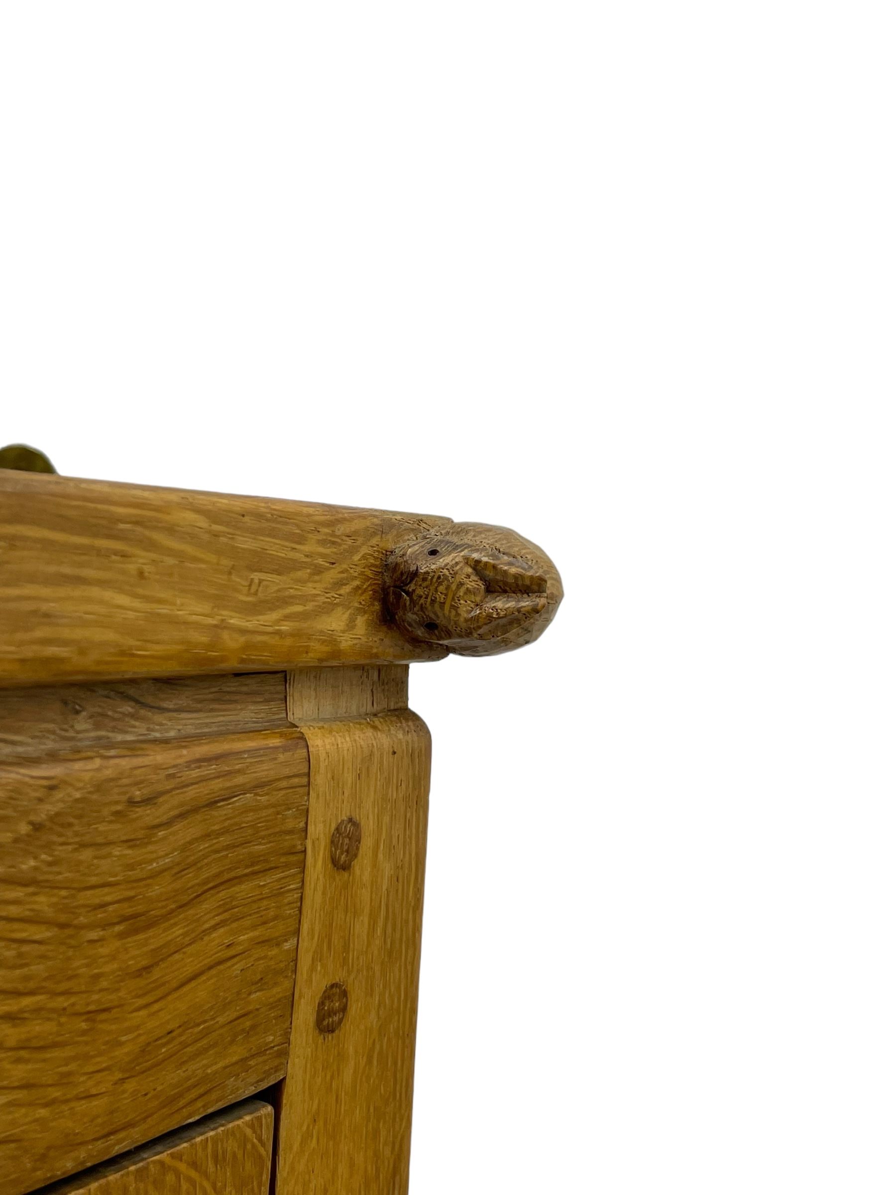 Rabbitman - oak corner cabinet, astragal glazed door enclosing three internal shelves, panelled upright corners, fitted with wrought metal hinges and latch, carved with rabbit signature, by Peter Heap, Wetwang 