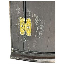 George III oak bow-front wall hanging corner cupboard, two doors enclosing four shaped shelves, brass hinges and escutcheons 