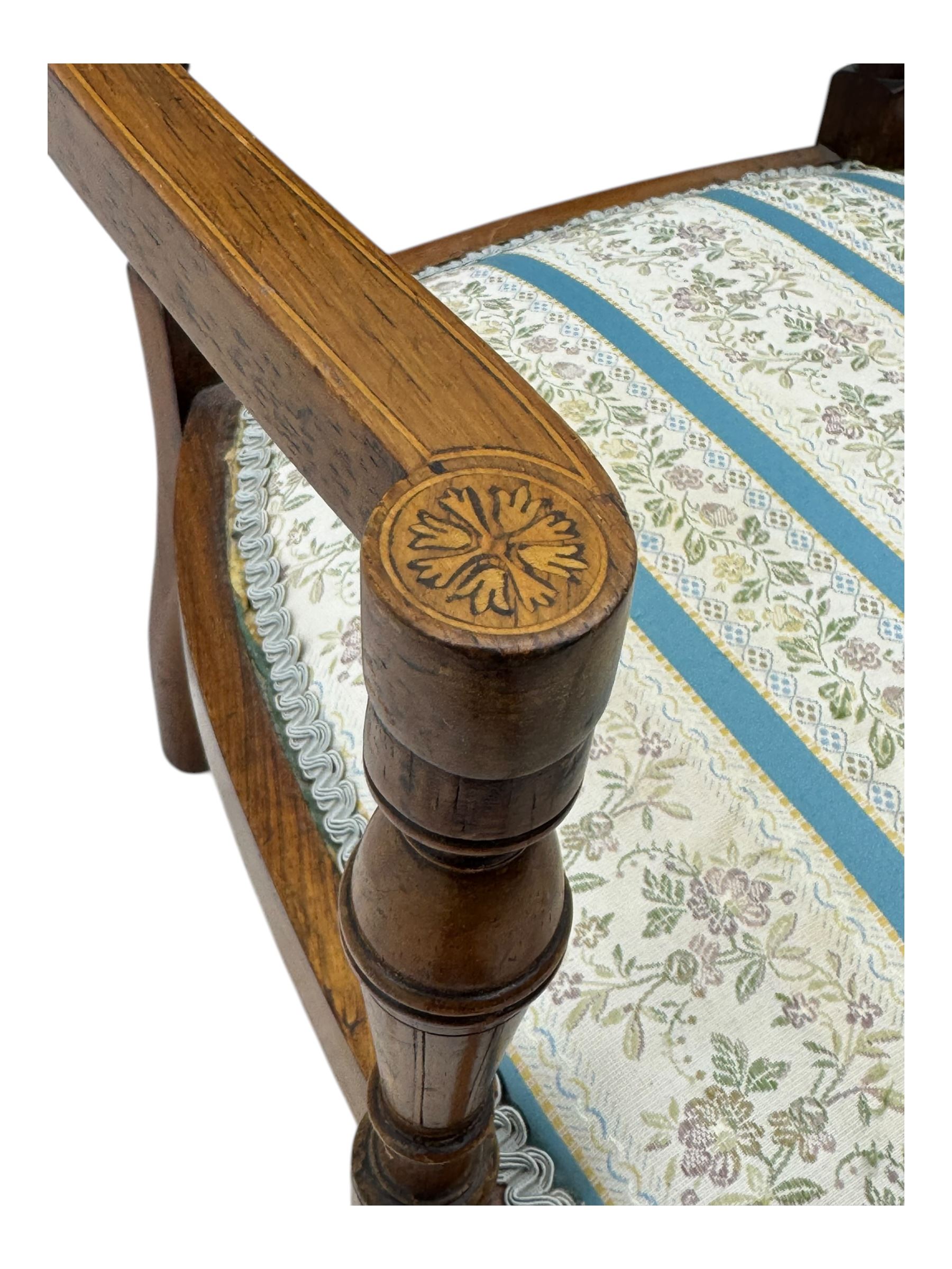 Edwardian inlaid rosewood elbow chair, pierced cresting rail over carved ribbon tie and oval inlaid panel, upholstered in stripe and floral pattern fabric, on square tapering supports with spade feet 