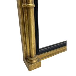 Regency design giltwood overmantel mirror, projecting cornice over pointed arcade frieze and foliate moulded upper edge, plain mirror plate within reed moulded ebonised slip, flanked by cluster columns with acanthus and scroll decorated Composite order capitals 