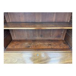 Early 19th century mahogany bureau bookcase, the projecting cornice over two Gothic-style astragal glazed doors enclosing two adjustable shelves, sloped hinged lid enclosing fitted interior and felt inset, four graduating drawers, on bracket feet