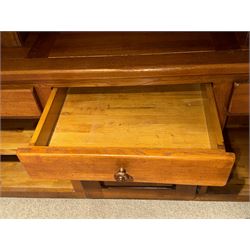 Large 20th century oak dresser, projecting cornice over open arched central section with two shelves, flanked by two panelled cupboards with two shelves, lower section with three drawers above three cupboards, on stile supports 