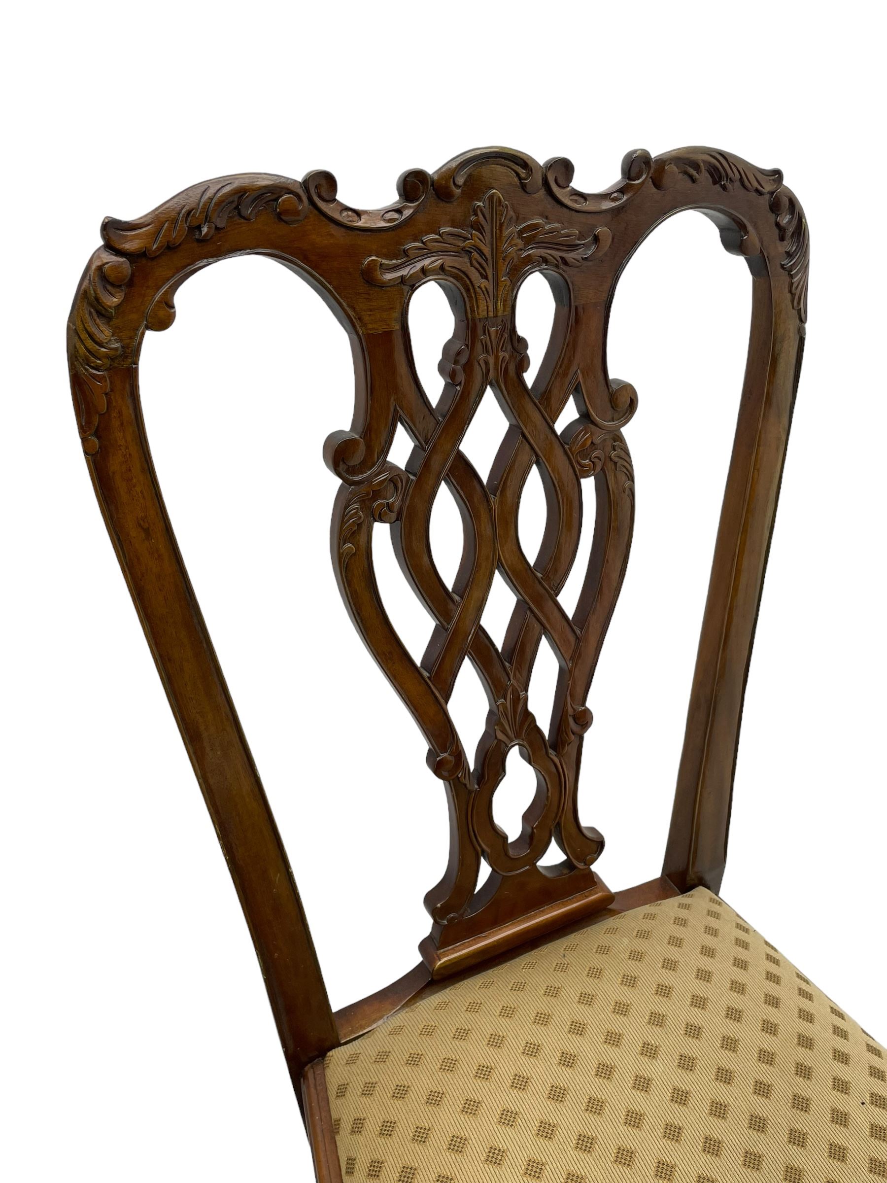 Set of twelve Chippendale design mahogany dining chairs, shaped cresting rail carved with foliage and C-scrolls, pierced interlaced splat with curled leaf decoration, upholstered drop-in seat, moulded seat rails, on scrolled acanthus carved cabriole supports with ball and claw feet 