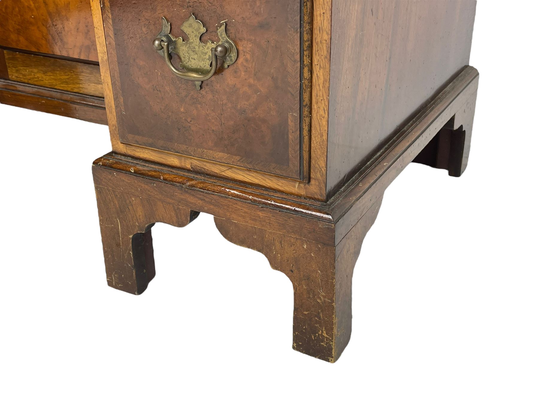 Georgian design figured walnut knee-hole desk, the rectangular moulded top with crossband, fitted with frieze drawer over six smaller drawers with oak linings, recessed cupboard enclosed by stepped arch mould door, on bracket feet