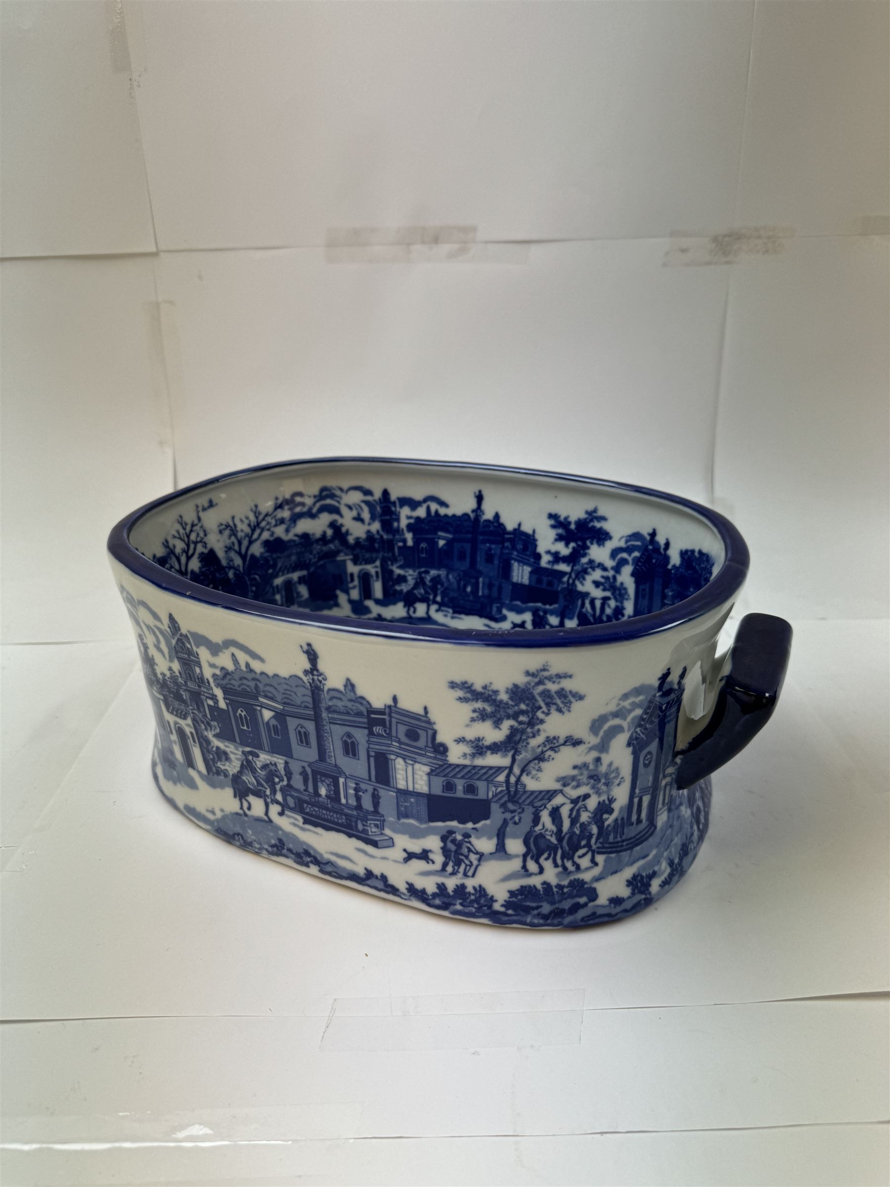 Pair of Victorian style blue and white footbaths, each with twin lug handles and transfer print decorated with city scape, H14cm