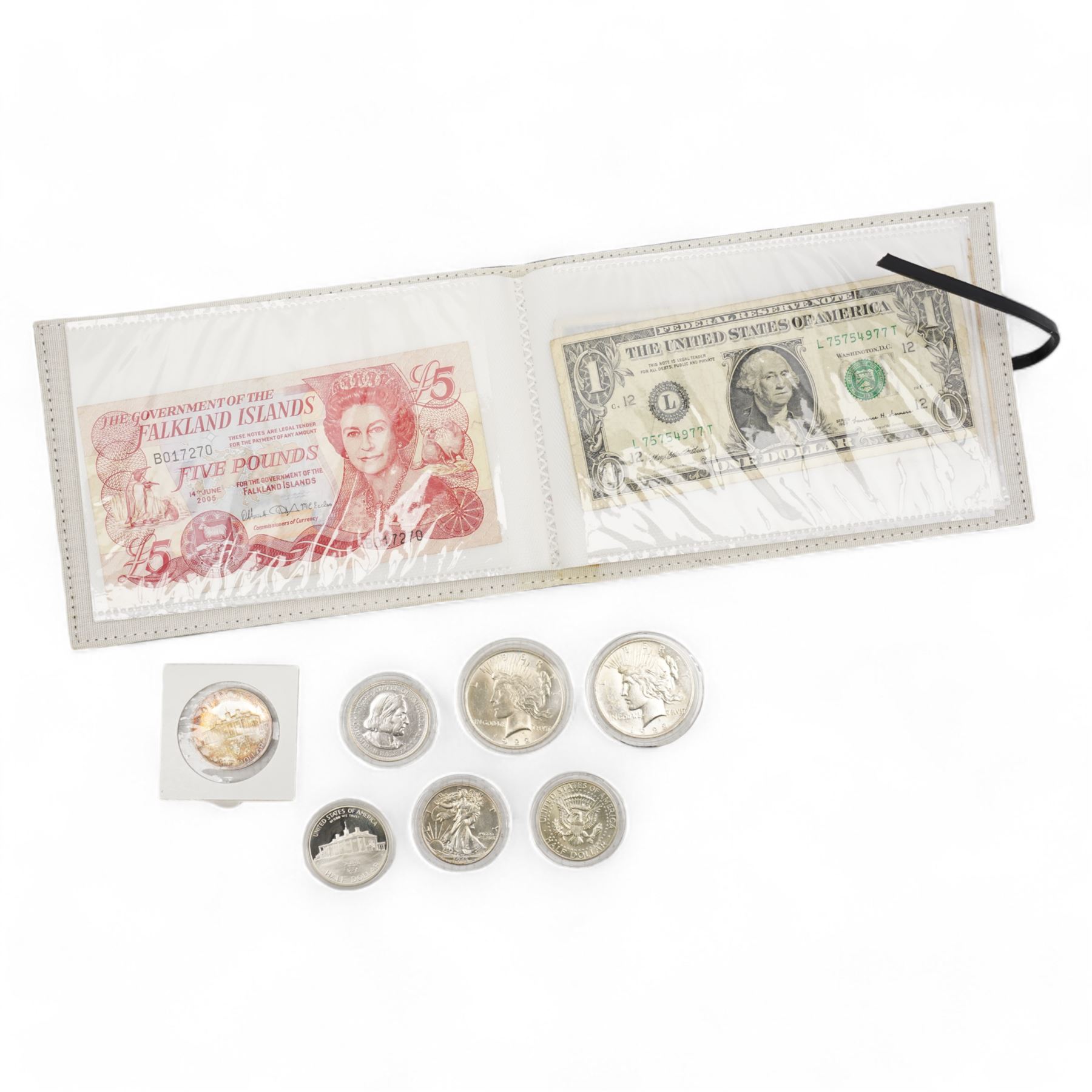 Coins and banknotes, including two United States of America 1922 silver peace dollars, 1943 half dollar, 1964 half dollar etc, The East African Currency Board 1st July 1941 five shillings note, Government of Hongkong 1st July 1954 one dollar note, The Government of the Falkland Islands 14th June 2005 five pounds note etc