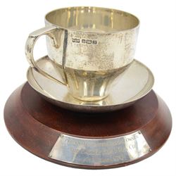 Silver trophy in the form of a cup and saucer 'Brooke Bond Tea Cup, Ayr, May 1976 presented to the winning owner' on wooden plinth Sheffield 1976 Maker Mappin & Webb and a silver spoon inscribed 'Goodwood Racecourse' L24cm (2) 