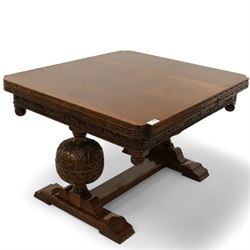 Early 20th century heavily carved oak draw leaf dining table, shaped rectangular top with recessed bead moulded edge, grape-vine carved frieze over large baluster vine and lobe carved end supports on sledge feet united by stretcher; with matched set of six dining chairs, upholstered in coral pink fabric 