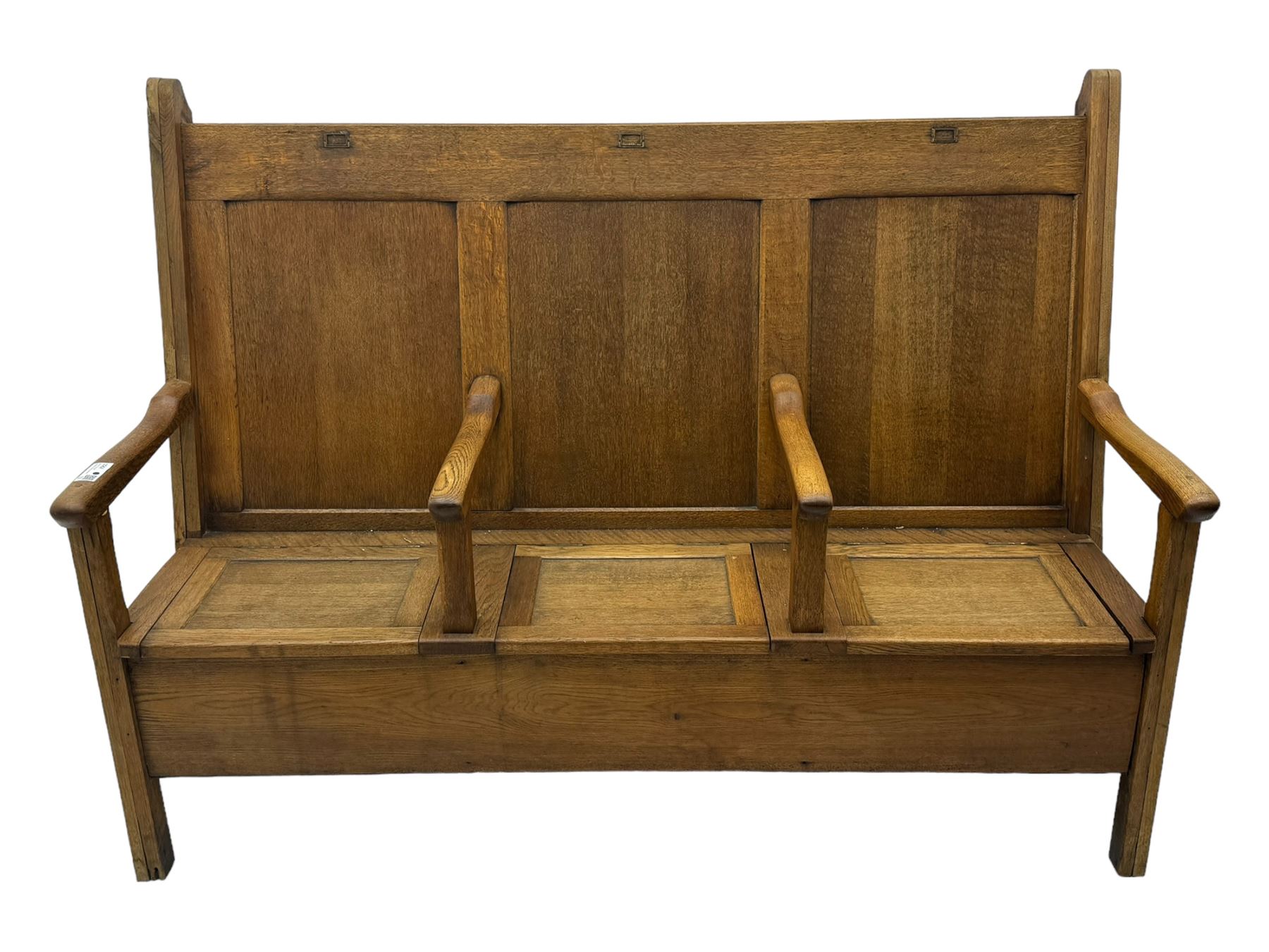 Early 20th century oak settle, featuring a high back with three panel sections and hinged lids, the bench seat divided into three sections, each with its own armrests, supported by square legs