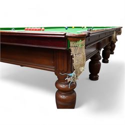 Riley - early 20th century full-sized mahogany billiards or snooker table, on eight turned baluster supports, with cue rack, scoreboard, balls and various cues 