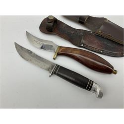 Western Boulder Colorado hunting knife the 11.5cm curving blade with maker's name to the ricassso, leather strip bound grip and aluminium pommel, in oak leaf decorated leather sheath L24cm; and J. Adams Sheffield hunting knife with curving blade and laminated wooden grip, in leather sheath (2)