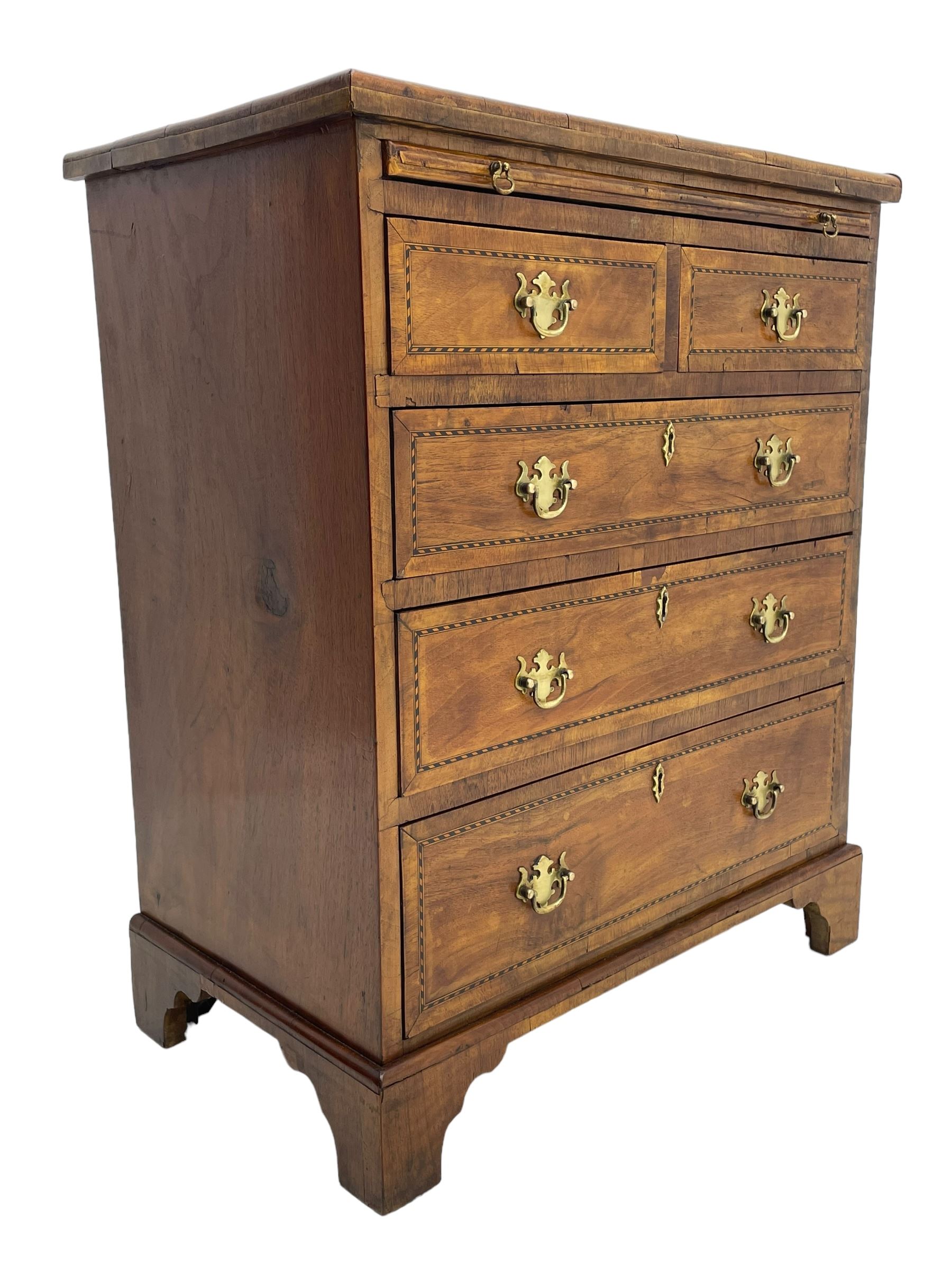 Small Georgian design walnut chest, moulded rectangular top with book-matched veneer enclosed by checkered stringing and crossbanding, brushing slide over two short and three long drawer, on bracket feet