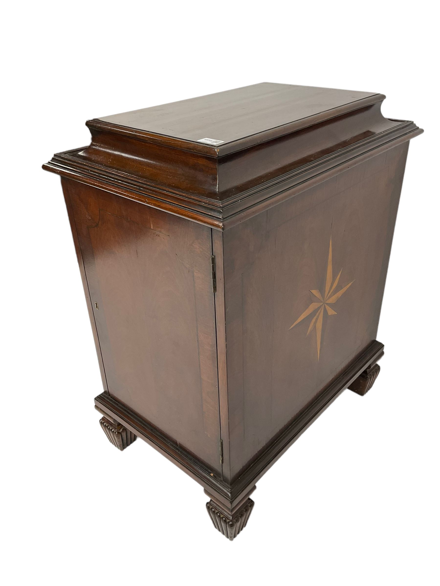 Regency style mahogany pedestal cabinet, sarcophagus top over single door enclosing drawer, the sides inlaid with star motifs, on square tapering lobe carved feet