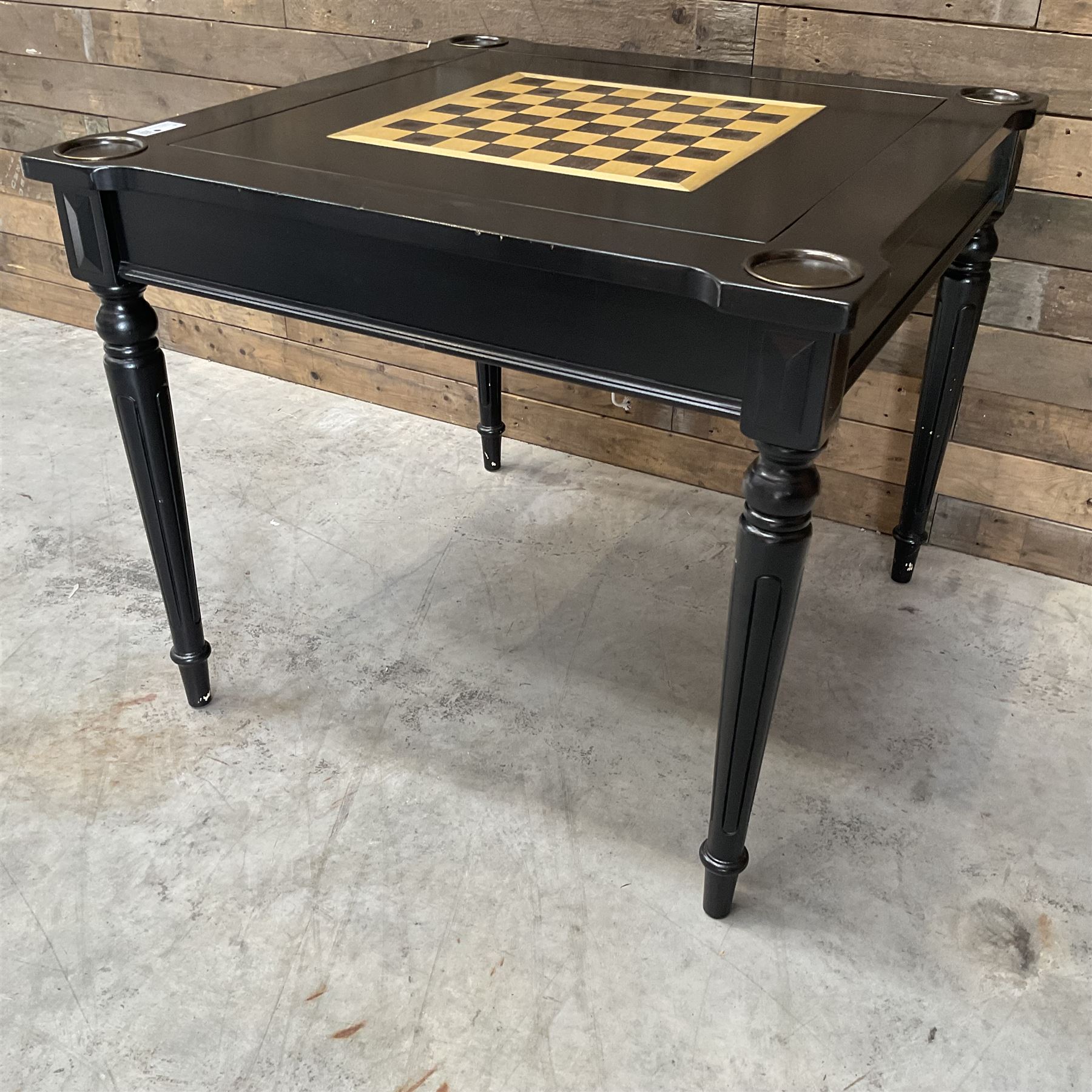 Ebonised square games table, reversible chessboard top revealing games compartment